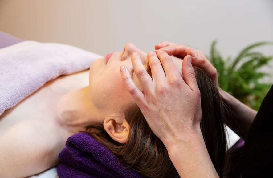 Practitioner delivering reiki to relaxed lady Bridport, Dorset